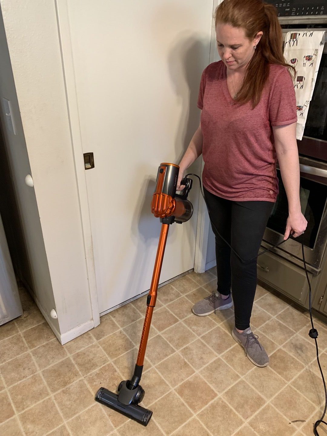 Woman vacuuming kitchen floor