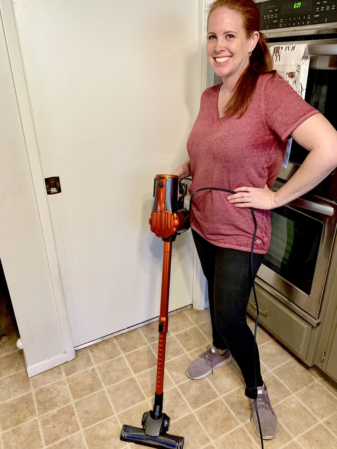 Woman holding vacuum in kitchen